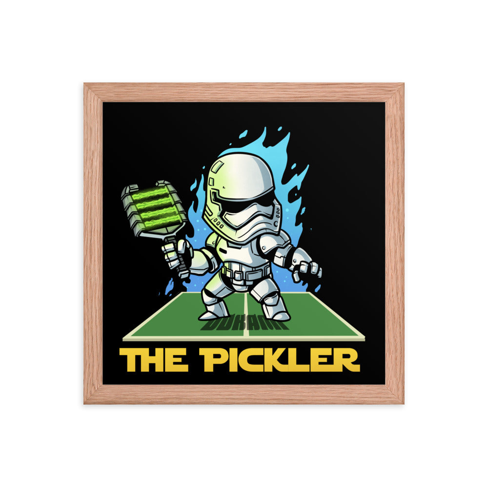 Square 12x12 inch framed poster showcasing 'THE PICKLER', a stormtrooper-inspired character with a pickleball paddle, in a minimalist red oak frame.