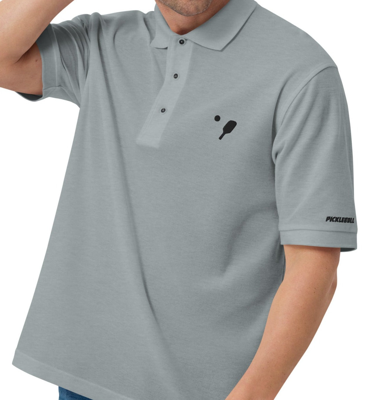 Man wearing a Cool Heather OOKAMI SPORTS Men's Premium Pickleball Polo Shirt, showcasing the embroidered pickleball logo on the chest and branded lettering on the left sleeve