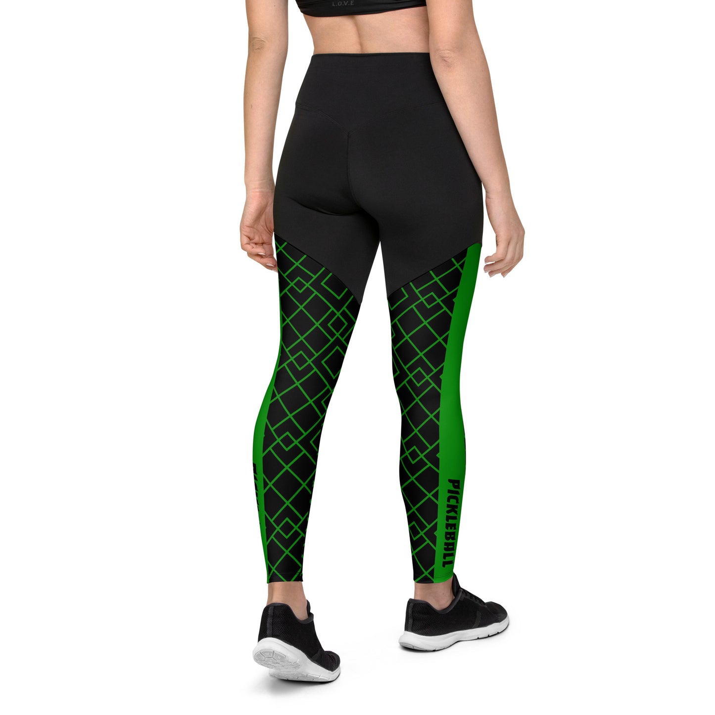 Back view of a woman wearing Neon Grid Pickleball Sports Leggings, highlighting the high-waisted design, double-layered belt, and bold green and black grid pattern.
