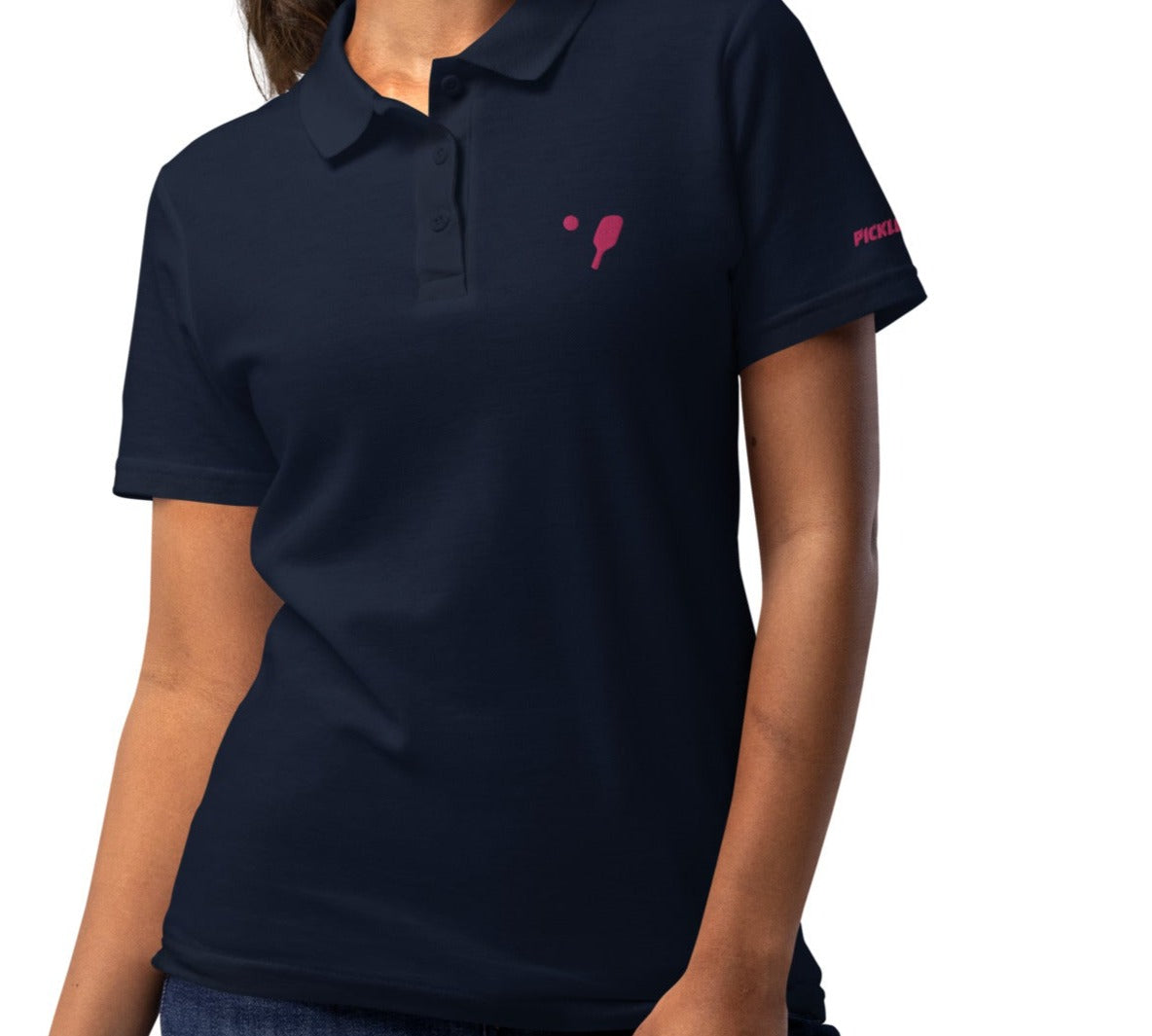 Active young woman showcasing a navy pickleball polo shirt with pink paddle badge, ideal for competitive or casual play.