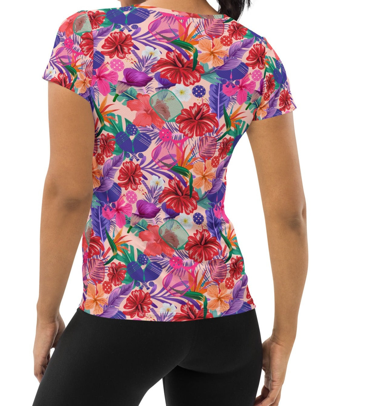 Back view of a woman sporting the Tropical Oasis Pickleball Performance Shirt, highlighting its colorful floral and pickleball paddle pattern. Ideal for active women's sports attire from OOKAMI SPORTS.