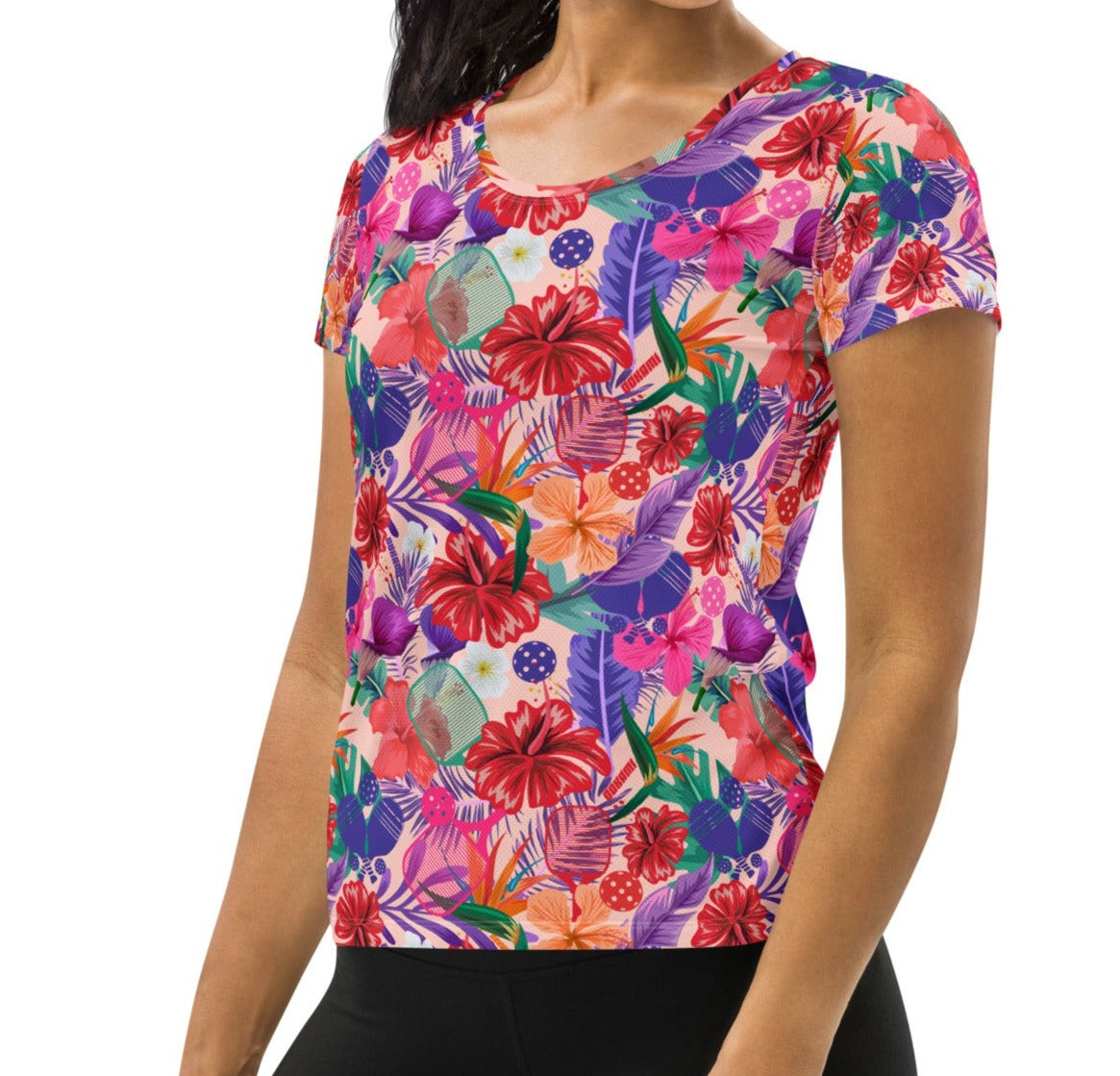 Side view of a woman in a Tropical Oasis Pickleball Performance Shirt by OOKAMI SPORTS. The shirt showcases a colorful floral pattern, ideal for stylish sports fashion.