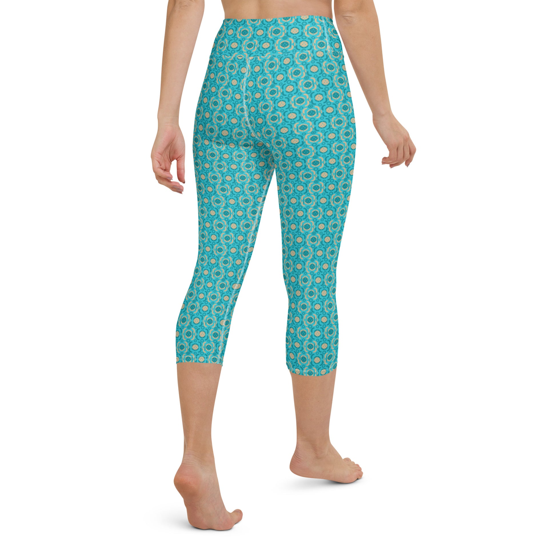 Rear view of Turquoise Tranquility Yoga Capri Leggings worn by a model, highlighting the curve-hugging design and detailed pickleball print, suitable for sports or casual wear.