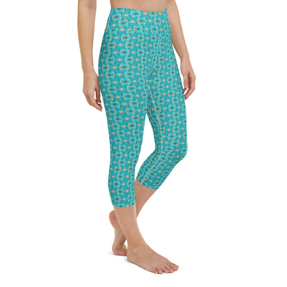 Turquoise Tranquility Pickleball Yoga Capri Leggings displayed on a model, featuring a vibrant turquoise hue with a detailed pickleball-themed print, offering a high-waisted fit that's ideal for active wear.