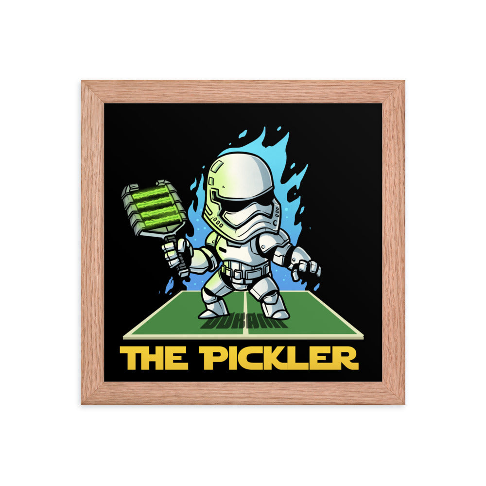 Compact 10x10 inch framed poster titled 'THE PICKLER' with a cartoon stormtrooper holding a green pickleball paddle, encased in a red oak frame.