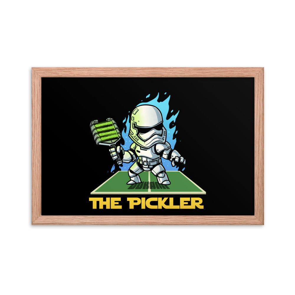 Rectangular 12x18 inch framed poster displaying 'THE PICKLER', with a stormtrooper-like figure on a pickleball court, framed in red oak for a bold look.
