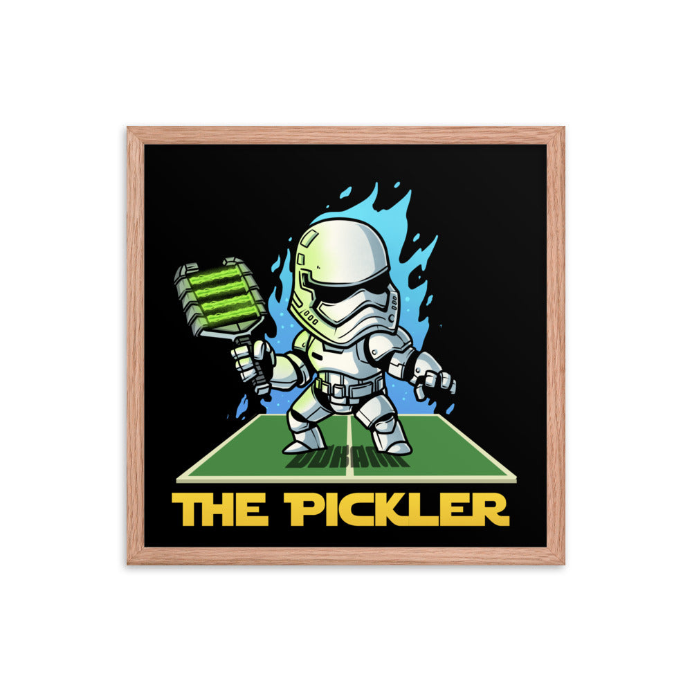 An 18x18 square framed poster in a red oak frame, showcasing 'The Pickler', a cartoonish Stormtrooper from Star Wars with a pickleball theme, positioned in a striking pose on a court, with blue flame-like graphics on a black background.
