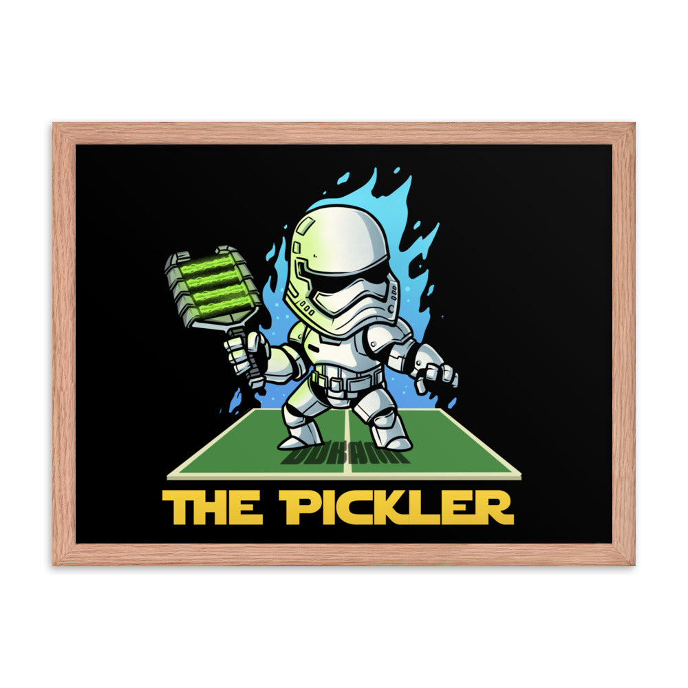A medium-sized 18x24 framed poster in a red oak frame, depicting 'The Pickler', a Stormtrooper-inspired character with a pickleball paddle, standing on a green court. The background is black, accented with vibrant blue graphics.