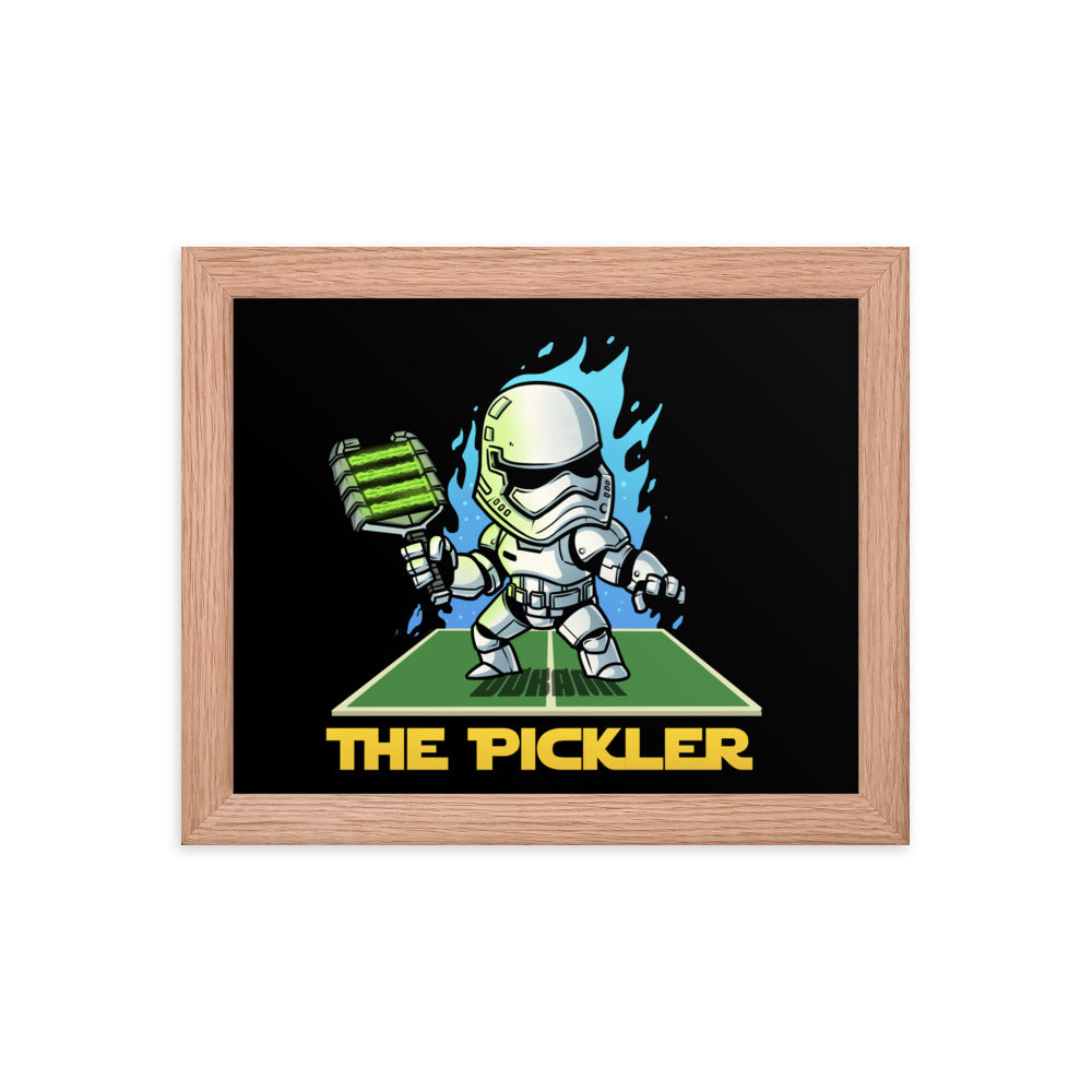 Small 8x10 inch framed poster of 'THE PICKLER', featuring a stormtrooper-like character wielding a pickleball paddle, set against a black backdrop within a warm red oak frame.
