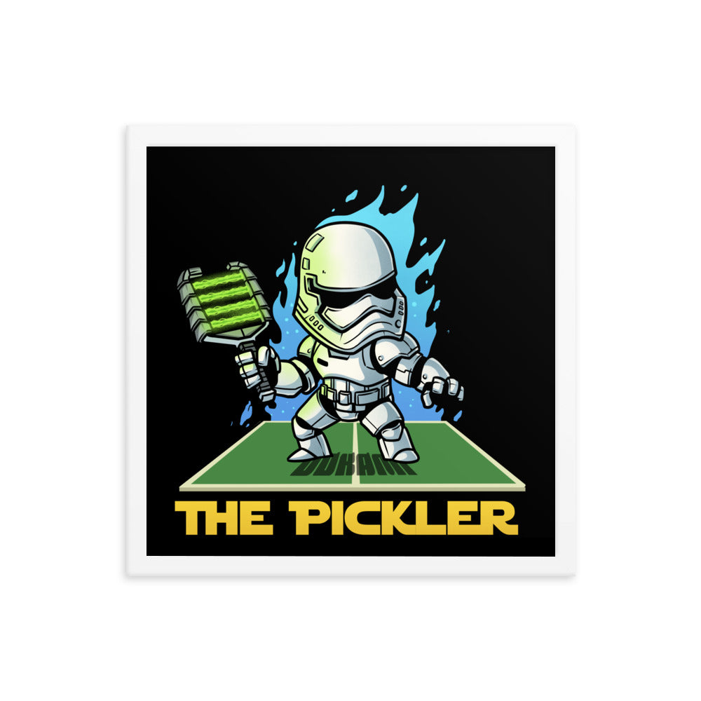  (16x16 inches): "A square framed poster featuring a white-armored pickleball player named 'The Pickler', standing ready with a paddle, against a fiery blue background. The frame is white.