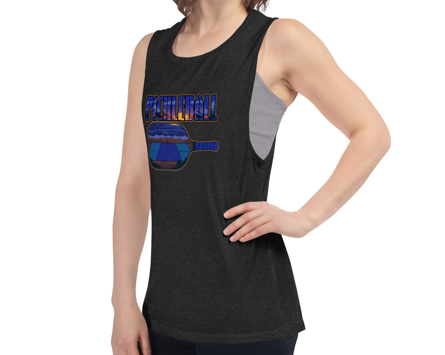 Woman wearing a black heather muscle tank with a pickleball sunset design, angled front view.