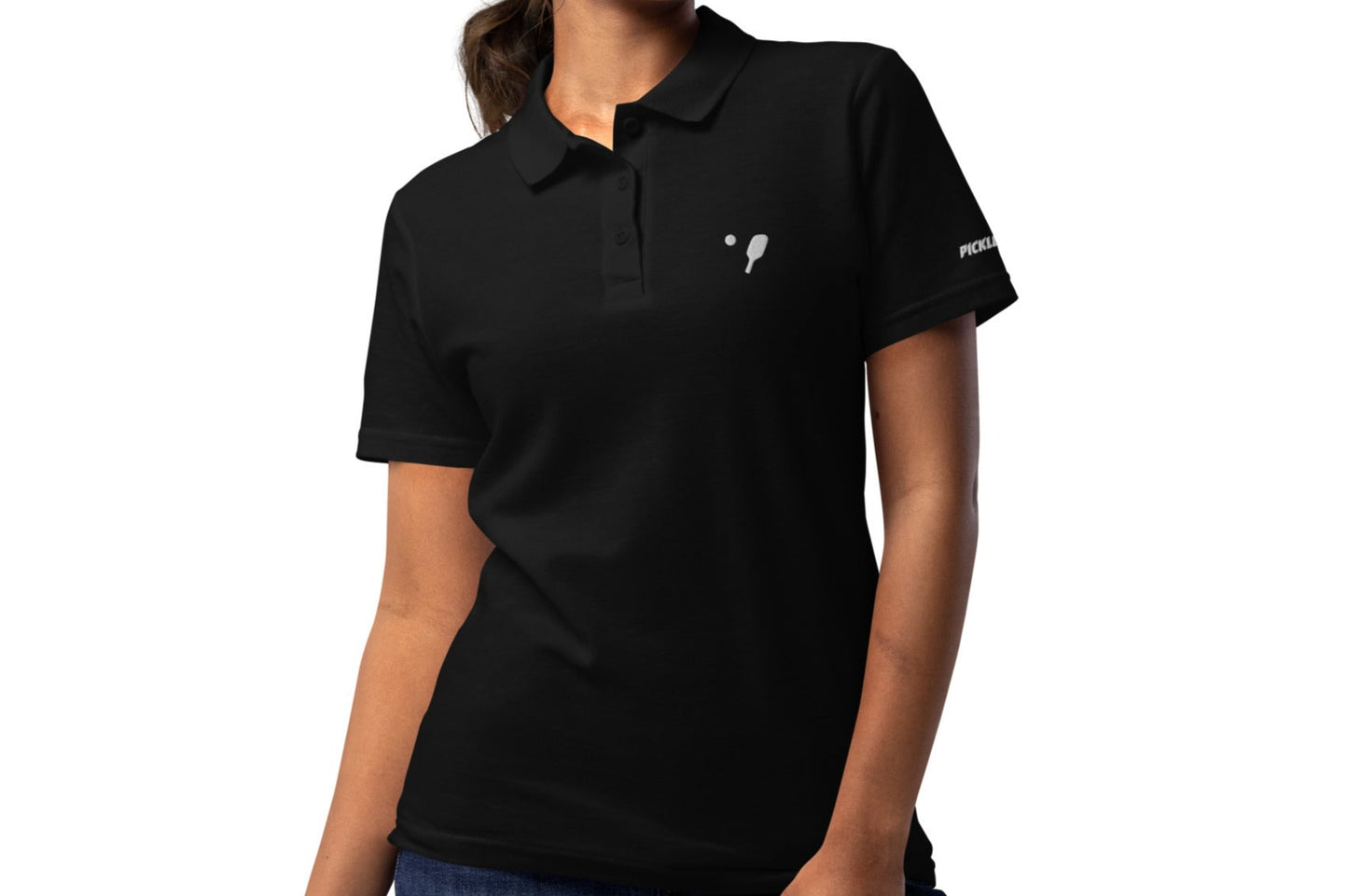 Frontal view of a woman in a black OOKAMI SPORTS Women’s Pique Pickleball Polo Shirt, designed with a pickleball logo on the chest and Pickleball text on the sleeve.